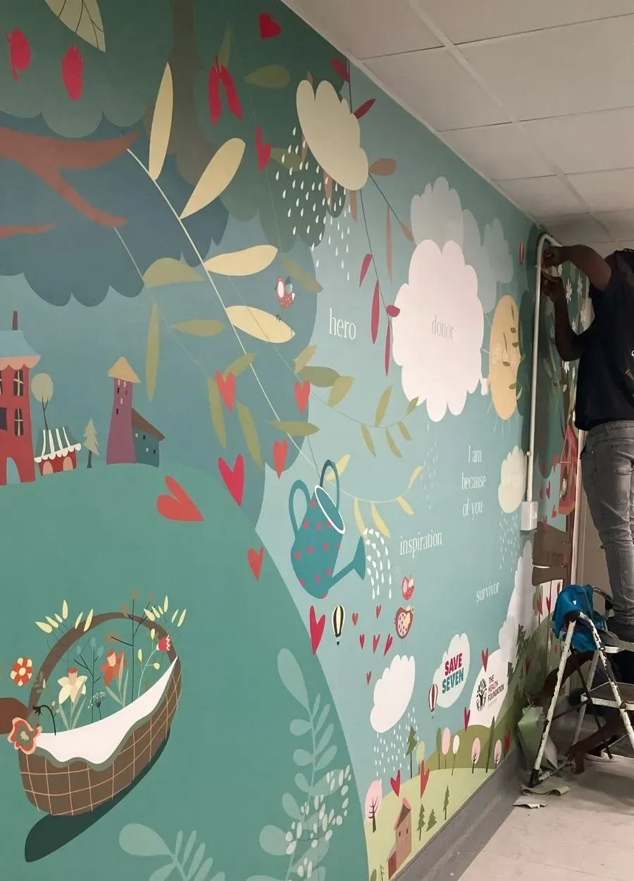 A mural being painted on the wall of the renovated room